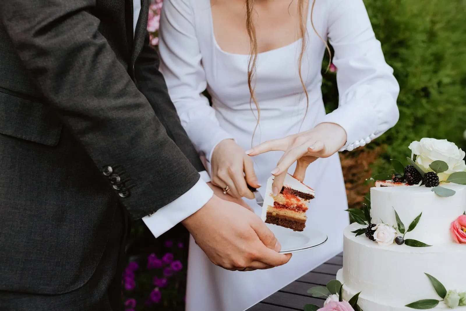 A bride and groom cutting a slice of their wedding cake