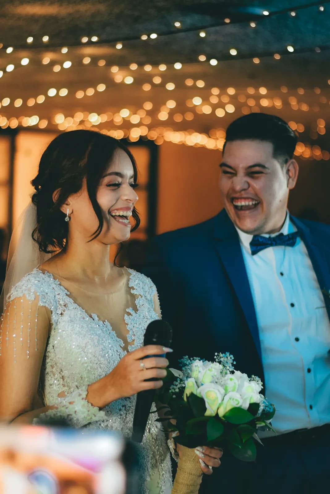 A bride and groom laughing together at their reception