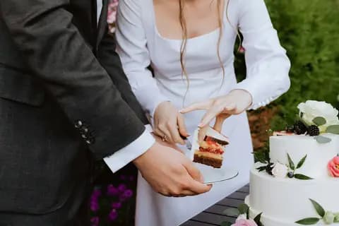 A bride and groom cutting a slice of their wedding cake